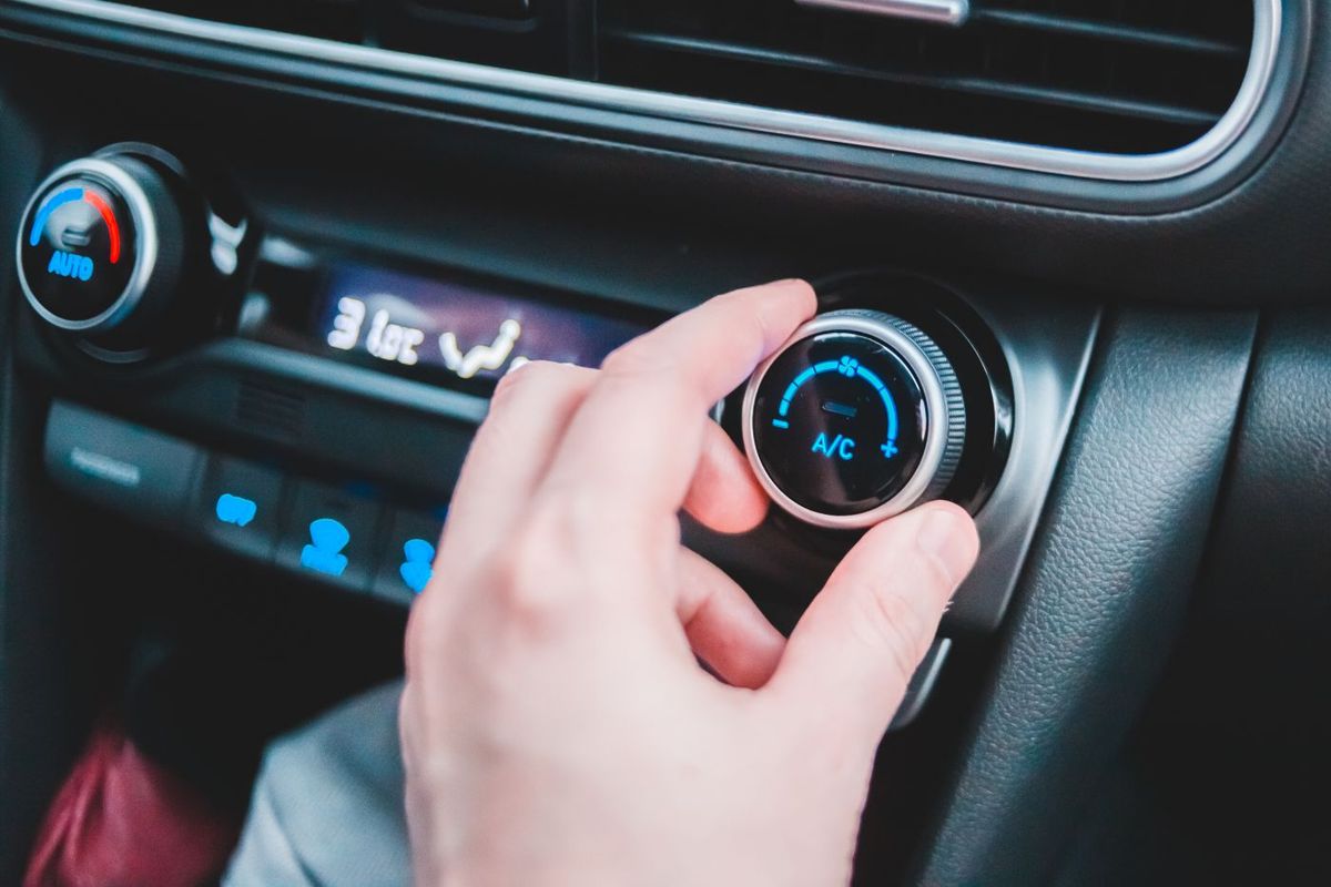 A hand adjusting a car's climate control