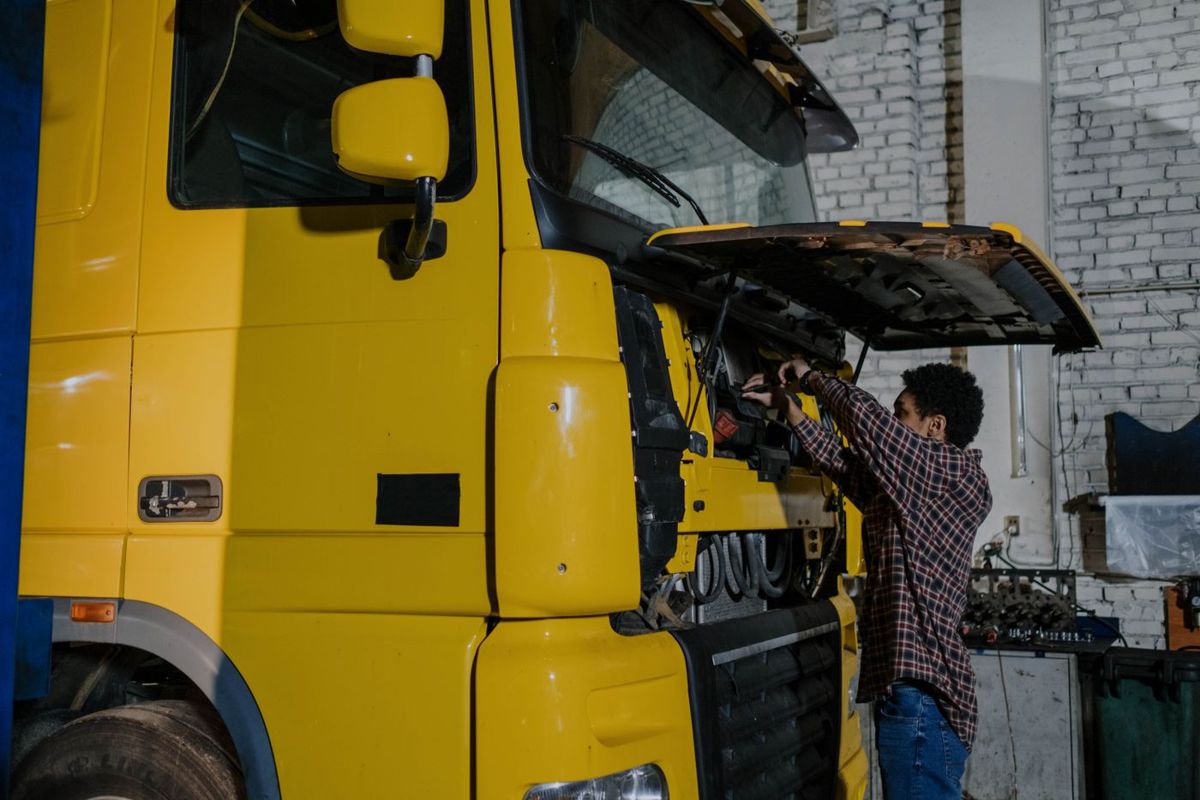 A mechanic working on a truck in a workshop