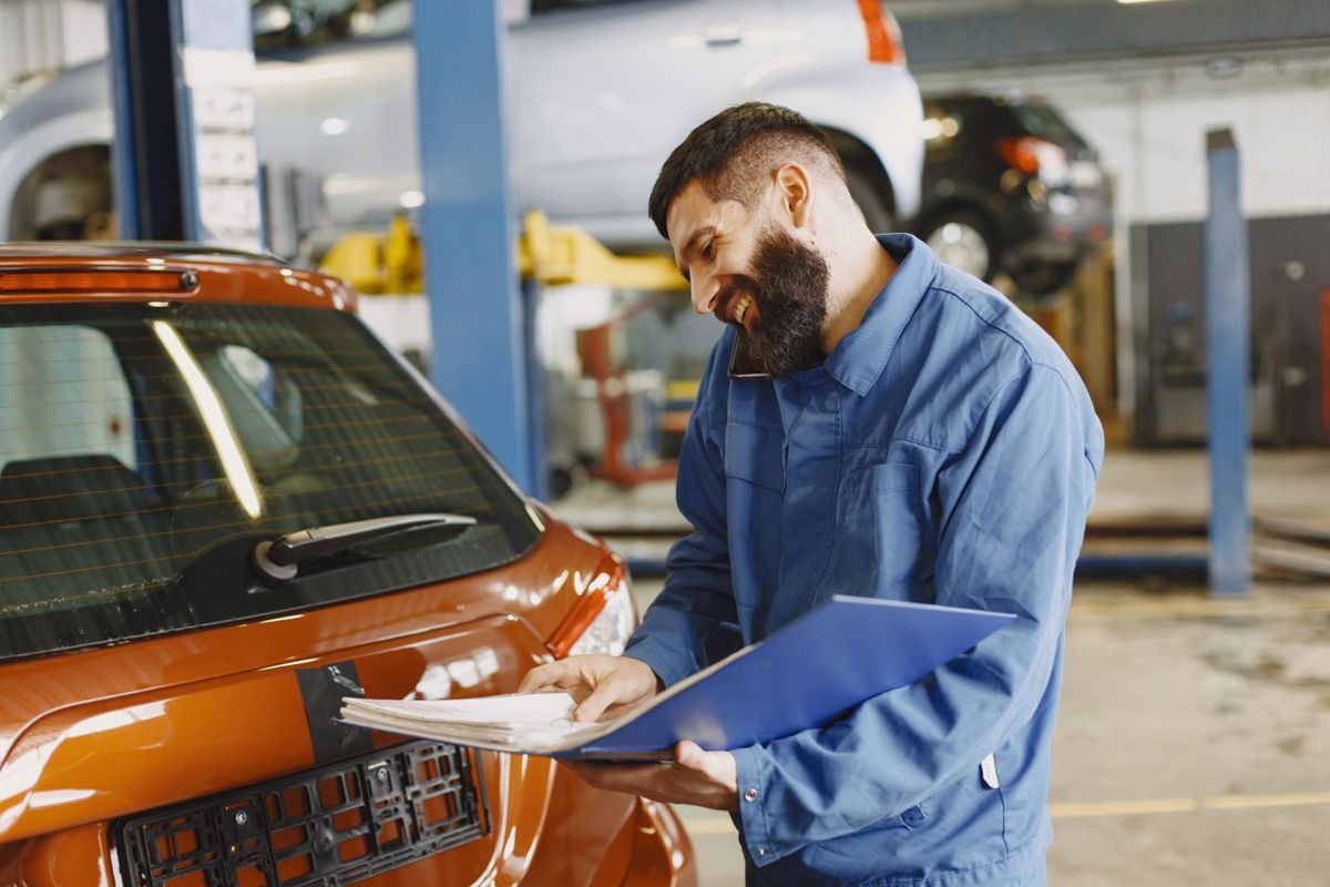 A mechanic checking a car in the MOT bay