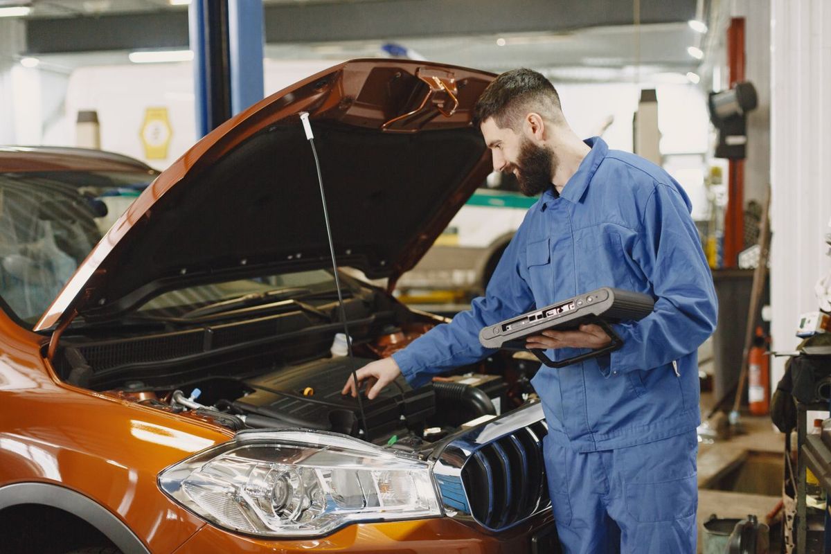 A mechanic working under the bonnet of a car